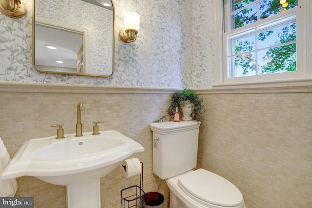 104 River Forest Ln, Fort Washington, MD 20744 - bathroom featuring wallpapered walls, a wainscoted wall, a sink, toilet, and tile walls