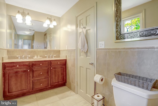 104 River Forest Ln, Fort Washington, MD 20744 - full bathroom featuring tile walls, tile patterned floors, toilet, double vanity, and wainscoting