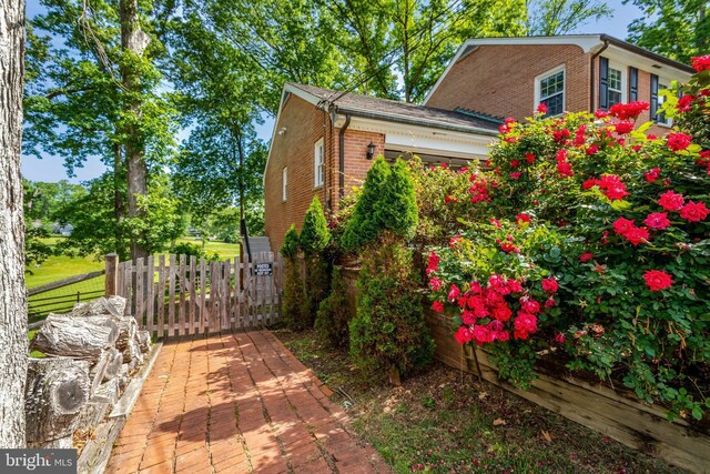 104 River Forest Ln, Fort Washington, MD 20744 - view of property exterior with brick siding, fence, and an attached garage
