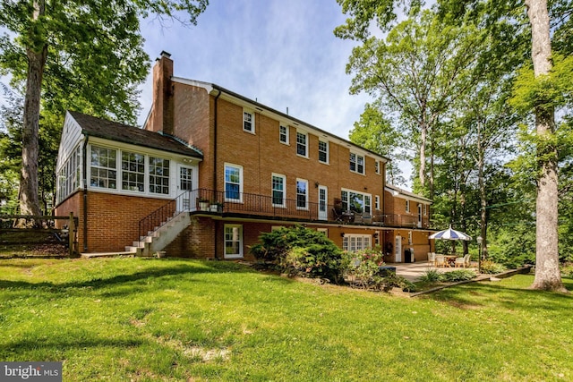 104 River Forest Ln, Fort Washington, MD 20744 - back of house with brick siding, stairway, a chimney, a patio, and a yard