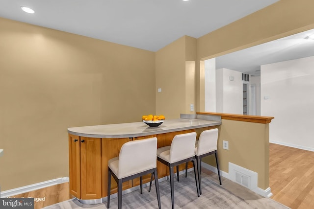 dining area with baseboards, light wood finished floors, and recessed lighting