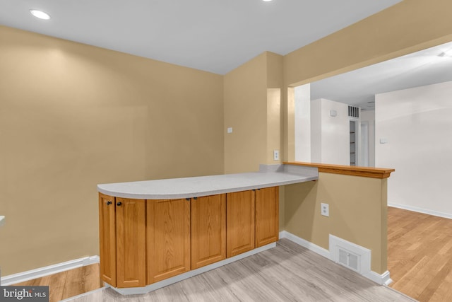 bar area featuring light wood-type flooring, baseboards, and recessed lighting