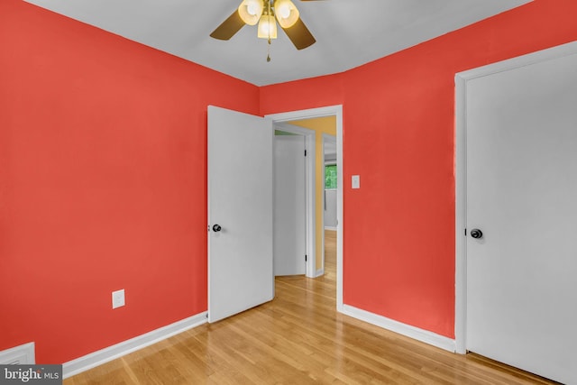 unfurnished bedroom featuring wood finished floors, baseboards, and ceiling fan