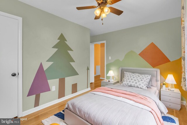 bedroom featuring wood finished floors, baseboards, and ceiling fan