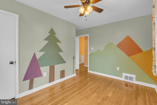 unfurnished room featuring wood finished floors, ceiling fan, and baseboards