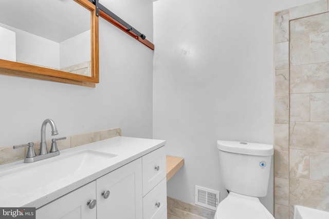 bathroom with toilet, vanity, and tile patterned floors