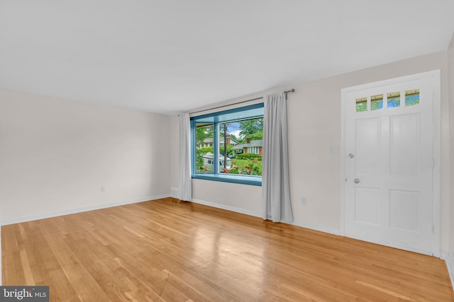foyer entrance featuring light wood finished floors and baseboards