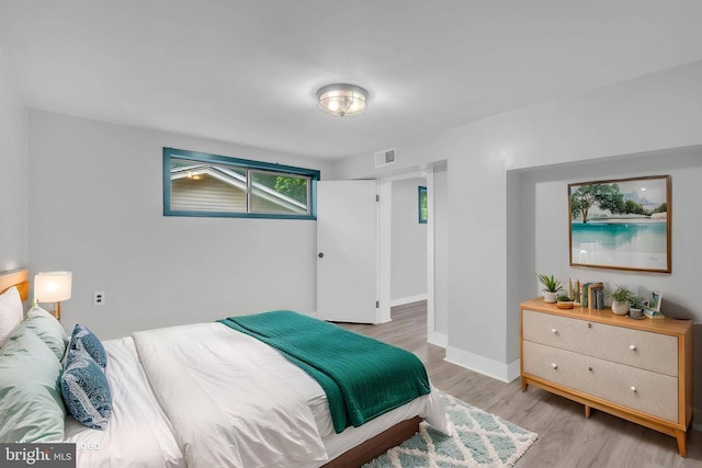 bedroom with light wood-style flooring and baseboards