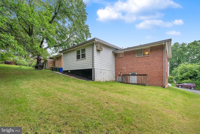 rear view of property featuring a yard, brick siding, and central air condition unit