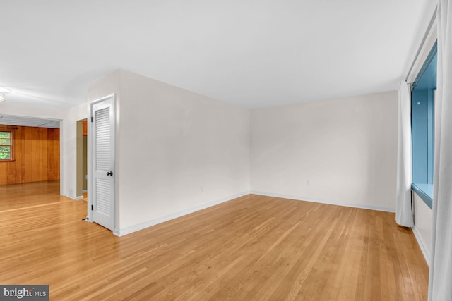 spare room featuring light wood-style floors and baseboards