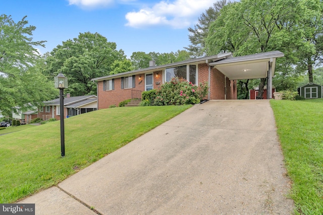 view of front facade featuring brick siding, a shed, a front yard, and driveway