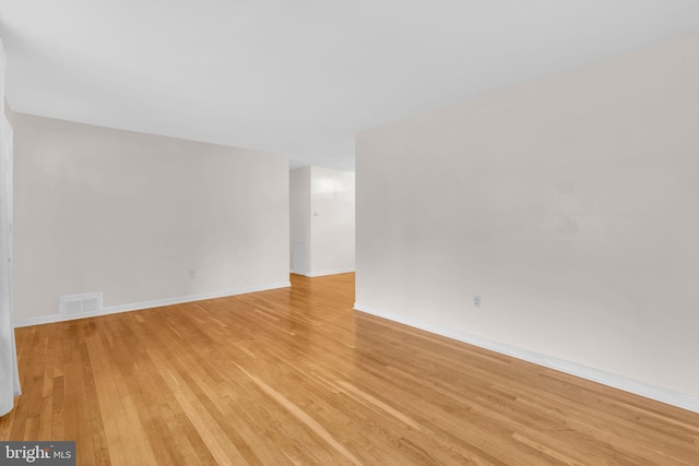 spare room with light wood-style floors and baseboards