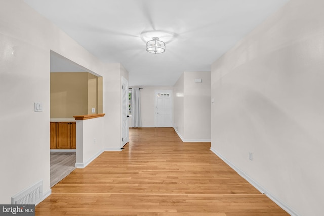 hall with light wood finished floors and baseboards