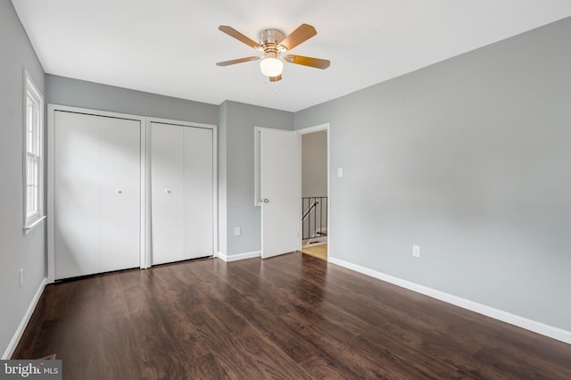 2836 Beechtree Ln, Woodbridge, VA 22191 - unfurnished bedroom featuring multiple closets, baseboards, wood finished floors, and ceiling fan