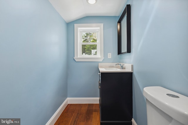 7608 Avondale Ave, Baltimore, MD 21224 - bathroom with lofted ceiling, wood finished floors, vanity, baseboards, and toilet