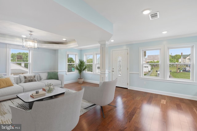 7608 Avondale Ave, Baltimore, MD 21224 - living room with crown molding, decorative columns, baseboards, dark wood-style floors, and a chandelier