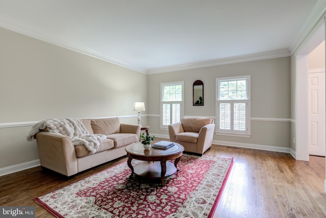 living room with wood finished floors, baseboards, and ornamental molding
