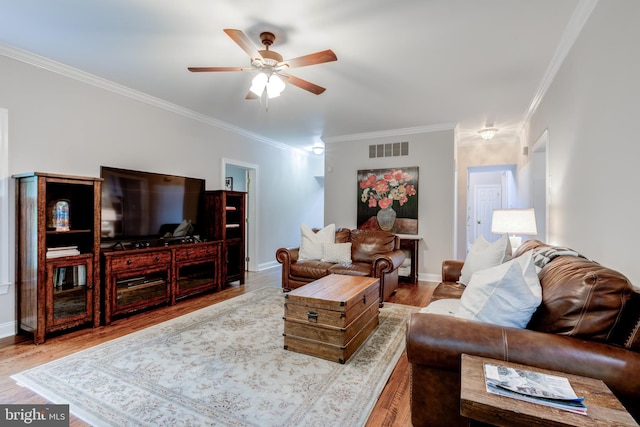 living room with ceiling fan, ornamental molding, wood finished floors, and baseboards
