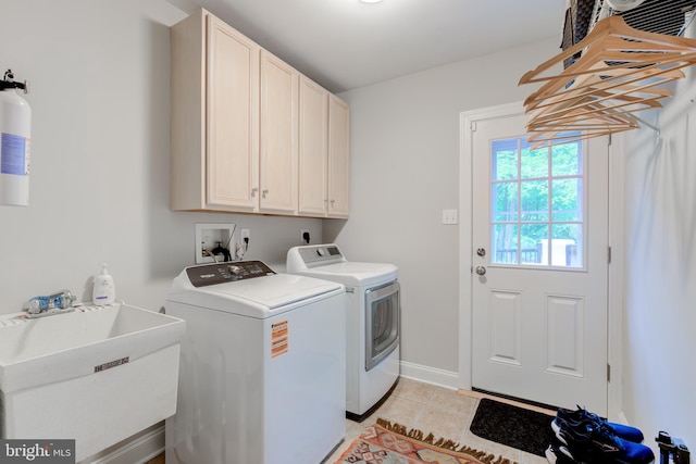 laundry room featuring cabinet space, washing machine and dryer, light tile patterned floors, and baseboards