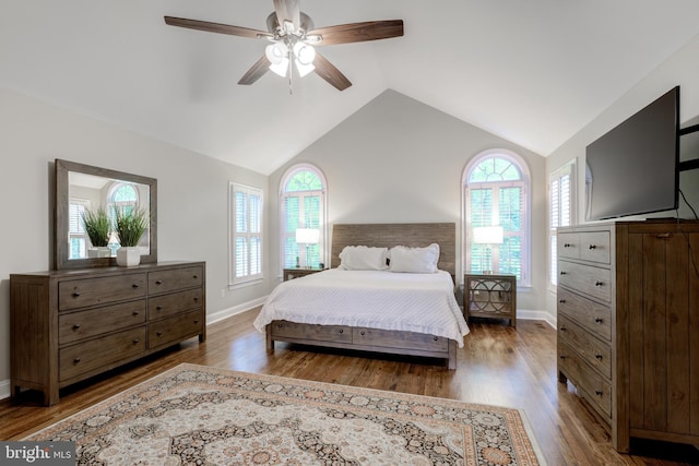bedroom with vaulted ceiling, wood finished floors, baseboards, and ceiling fan