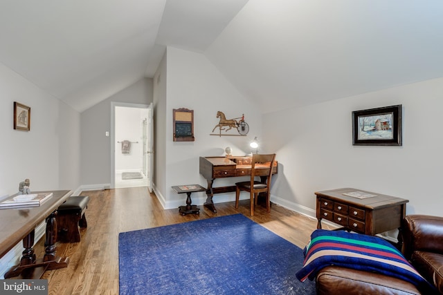 home office featuring wood finished floors, lofted ceiling, and baseboards