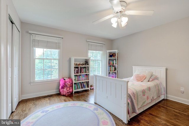 bedroom featuring wood finished floors, baseboards, ceiling fan, and a closet