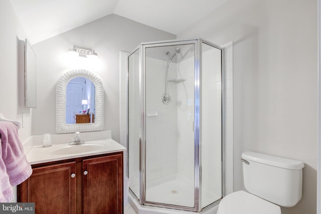 full bath featuring a stall shower, toilet, vaulted ceiling, and vanity