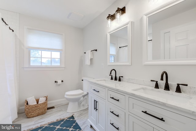 bathroom with toilet, double vanity, baseboards, and a shower with shower curtain