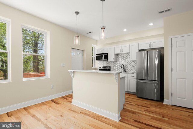 3827 Boarman Ave, Baltimore, MD 21215 - kitchen featuring appliances with stainless steel finishes, light countertops, decorative backsplash, light wood-style flooring, and baseboards