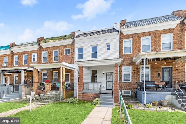 3827 Boarman Ave, Baltimore, MD 21215 - townhome / multi-family property with covered porch, brick siding, and a front lawn