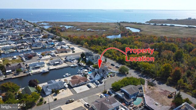 aerial view of property's location with a nearby body of water and nearby suburban area