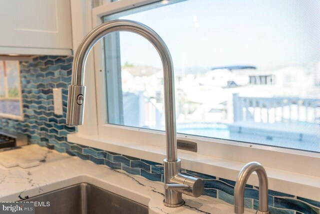kitchen view of a sink and white cabinets