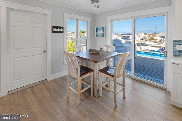 dining room featuring light wood-style flooring and baseboards