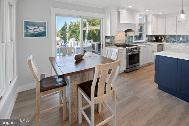 dining room with light wood-style floors, recessed lighting, and baseboards
