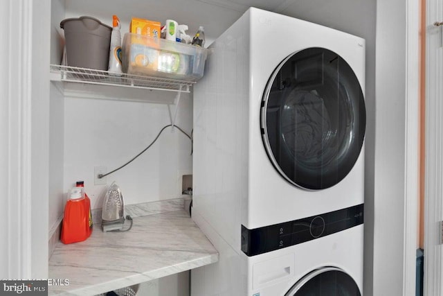 clothes washing area featuring stacked washer / dryer