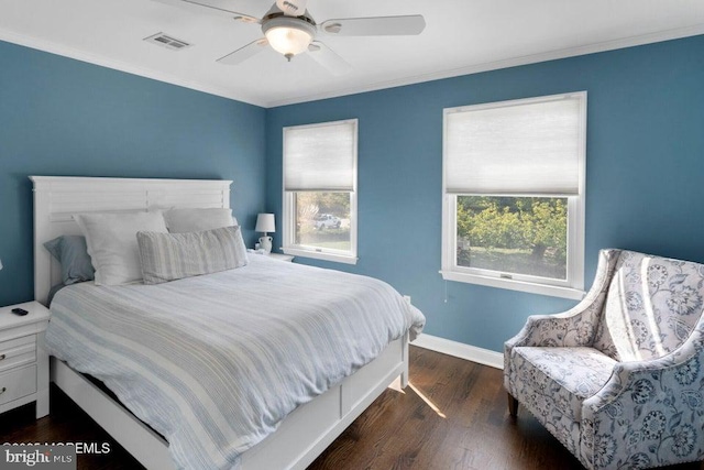 bedroom featuring dark wood-style flooring, crown molding, baseboards, and ceiling fan