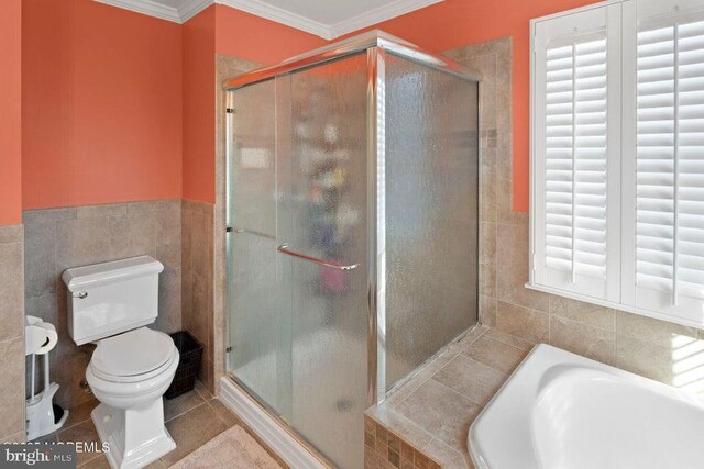 bathroom featuring a shower stall, toilet, tile walls, crown molding, and a bath