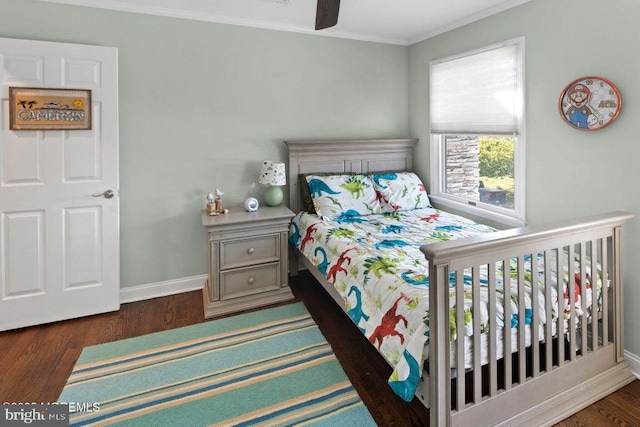 bedroom with crown molding, baseboards, and wood finished floors