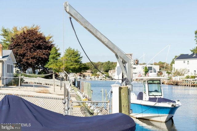 dock area with fence and a water view