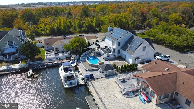 aerial perspective of suburban area with a heavily wooded area and a large body of water