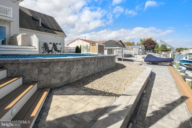 view of pool with a swimming pool, fence, and a patio