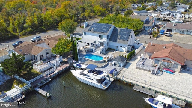 aerial perspective of suburban area featuring a large body of water and a pool area