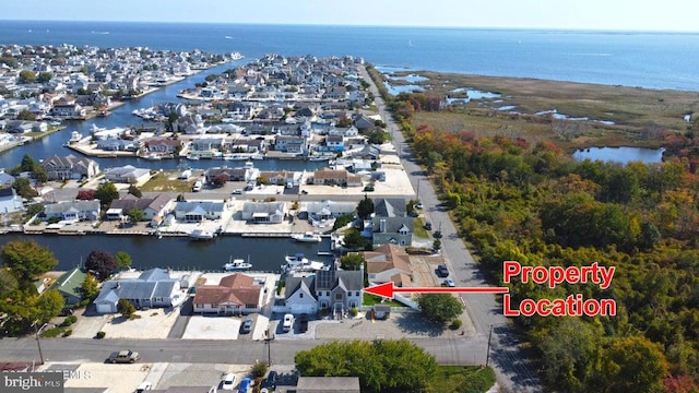 aerial view of property's location with a large body of water and nearby suburban area