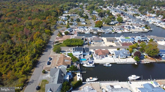 aerial view of property's location with a large body of water, nearby suburban area, and a heavily wooded area