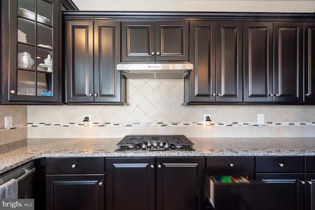 kitchen featuring black gas cooktop, under cabinet range hood, and light stone countertops