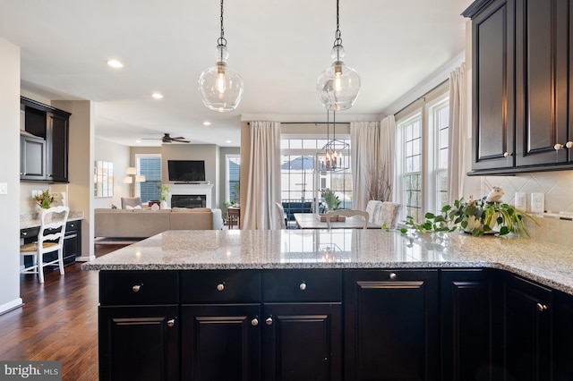 kitchen featuring open floor plan, backsplash, ceiling fan, dark wood finished floors, and recessed lighting