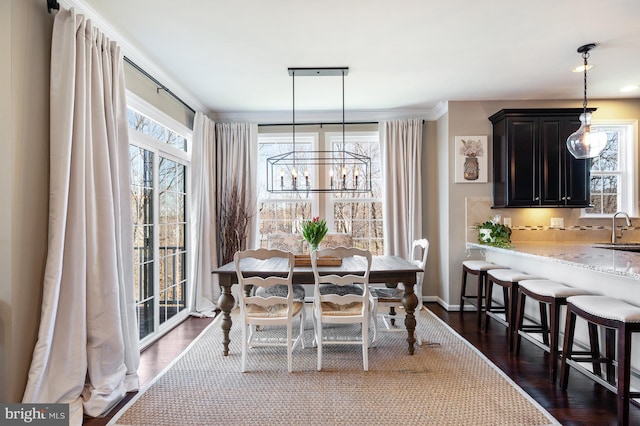 dining room featuring a chandelier, dark wood-style flooring, and baseboards