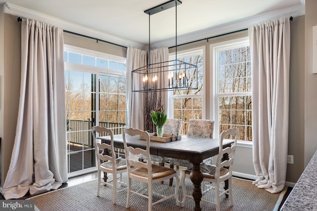 dining area featuring a chandelier, ornamental molding, and baseboards