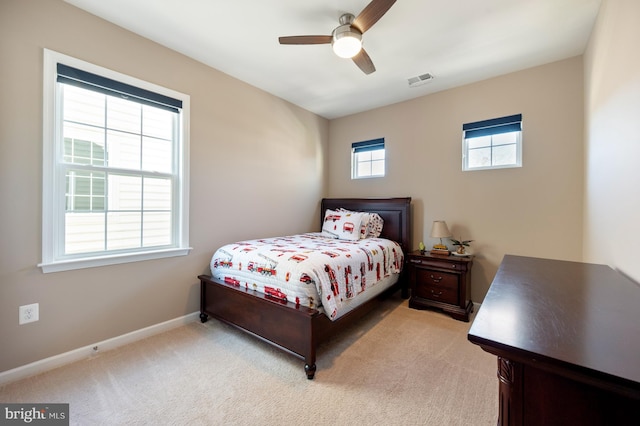 bedroom with light colored carpet, baseboards, and ceiling fan