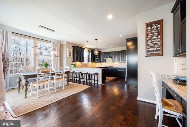 dining area featuring dark wood finished floors, recessed lighting, a chandelier, and baseboards